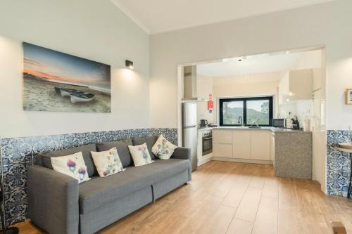 a living room with a couch and a kitchen at Casa Curva do Rio in Melres