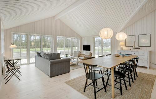 Beautiful Home In Aakirkeby With Kitchen في Vester Sømarken: مطبخ وغرفة معيشة مع طاولة وكراسي