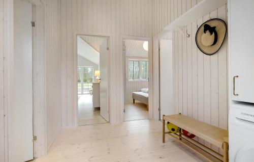 un couloir avec des murs blancs et une horloge sur le mur dans l'établissement Beautiful Home In Aakirkeby With Kitchen, à Vester Sømarken