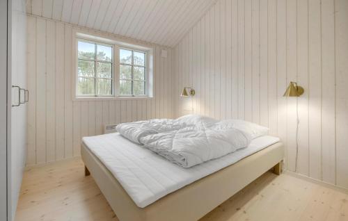 a bedroom with a bed with white sheets and a window at Beautiful Home In Aakirkeby With Kitchen in Vester Sømarken