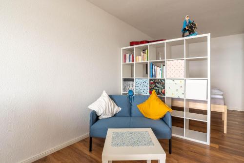 a living room with a blue couch and a book shelf at Immerschön in Schilksee
