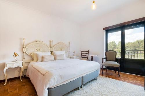 a bedroom with a large bed and a balcony at Vintage Charm Meets Modern Comfort 1 in Aguda