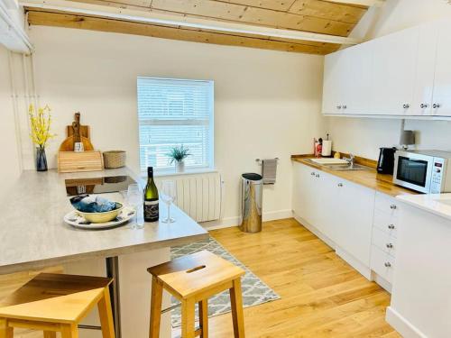 a kitchen with white cabinets and a counter top at The Ilkley Loft Suite in Ilkley