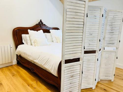 a bedroom with a large bed with white doors at The Ilkley Loft Suite in Ilkley