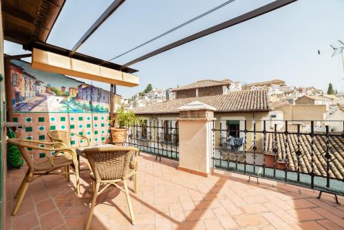 a patio with a table and chairs on a balcony at Hotel Posada del Toro in Granada