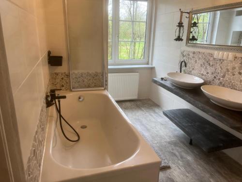 uma casa de banho com 2 lavatórios e uma banheira e 2 lavatórios em Gasthof Hasenmühle em Bad Friedrichshall