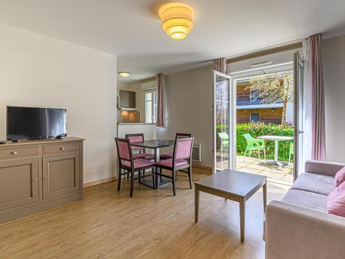 a living room with a couch and a table and chairs at Vacancéole - Les Rives de Pont-Aven in Pont-Aven