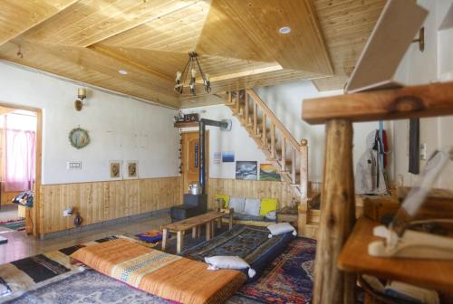 - un salon avec un plafond en bois et un escalier dans l'établissement Gharsa Homestay, à Manali