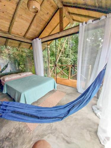a bedroom with a hammock in a tent at Suíte com cachoeira no quintal in Antônio Carlos
