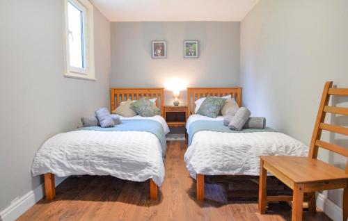 a room with two twin beds and a table at Gorgeous Home In Passais-Villages in Saint-Siméon