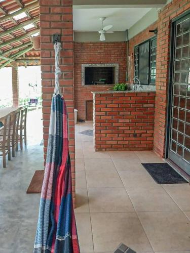 a kitchen with a towel hanging on a brick wall at Suíte com cachoeira no quintal in Antônio Carlos