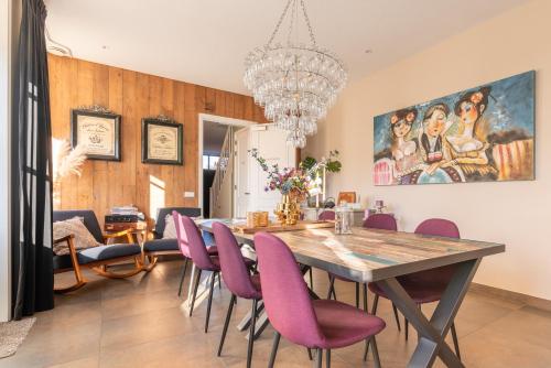 een eetkamer met een tafel en paarse stoelen bij Bed and Breakfast Geliefd in Voorhout