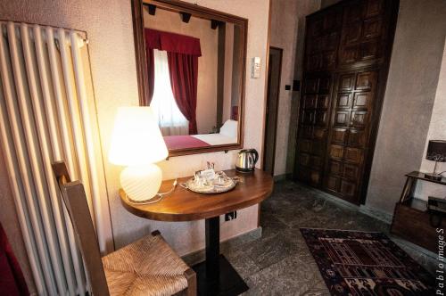 a room with a wooden table and a lamp at Le Charaban in Aosta