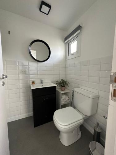 a bathroom with a toilet and a sink and a mirror at Sweet Stay in San Martín de los Andes