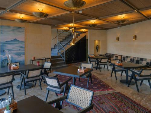 a restaurant with tables and chairs and a staircase at Very Peri Cappadocia - The Lifestyle Luxury Design Hotel in Uchisar