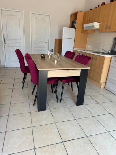 une cuisine avec une table en bois et des chaises rouges dans l'établissement Appartement Argeles Plage, à Plage dʼArgelès