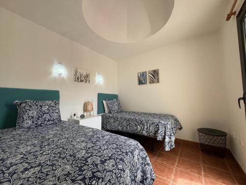 a bedroom with a bed and a chair at Villa Olympia Lovely, Close to Town and Beaches with Private Pool & Fast WiFi in Corralejo