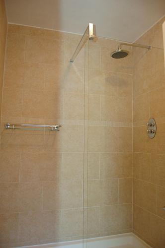 a bathroom with a shower with a glass door at Abermaw Sea View Apartment in Barmouth
