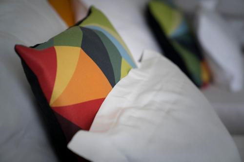 バラトンフェニヴェシュにあるFenyves Yacht Club Superiorの白い枕の横に座るカラフルな傘