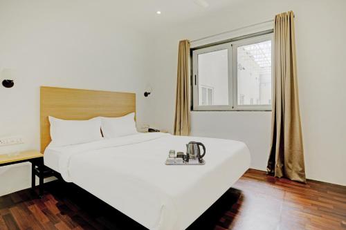 a large white bed in a room with a window at Townhouse 446 Vista Suites in Turambhe