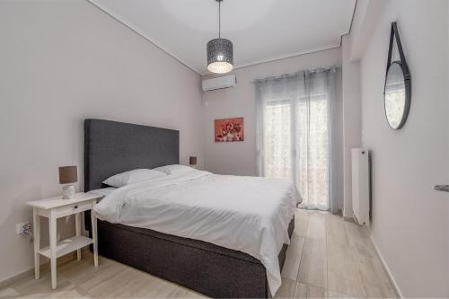 um quarto branco com uma cama grande e uma janela em Marina Zeas Hidden Gem em Piraeus