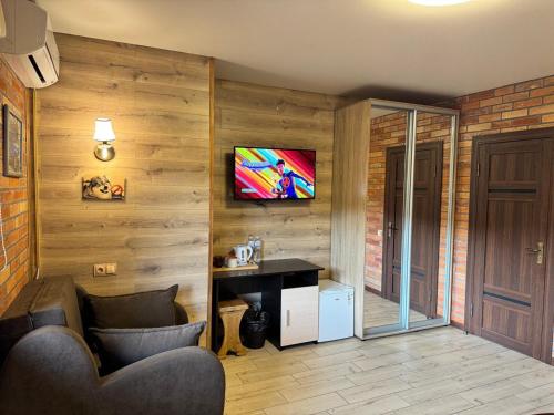a room with a desk and a tv on a wall at Готель Довбуш in Yaremche