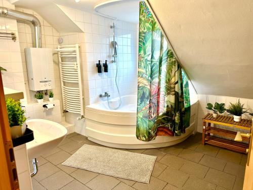 a bathroom with a tub and a shower curtain at Dschungel Wohnung, geräumig, Netflix, Sonos, zentral in Duisburg