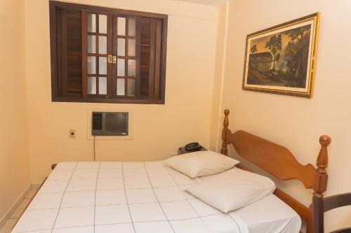 a bedroom with a bed and a window at Hotel Colonial in São Lourenço