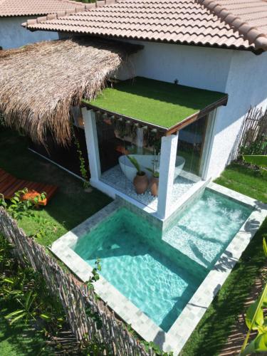 a house with a swimming pool next to a house at POUSADA ZAYA in São Miguel dos Milagres