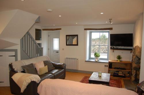 a living room with a couch and a television at Ty Del - Beautiful Home in Tywyn in Tywyn