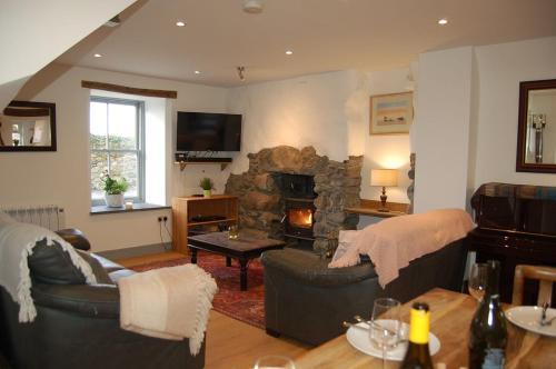 a living room with two couches and a stone fireplace at Ty Del - Beautiful Home in Tywyn in Tywyn