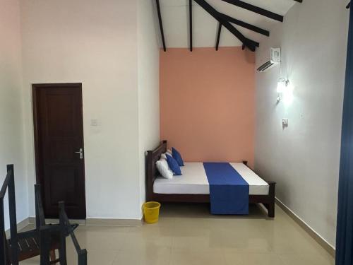 a bedroom with a bed with blue and white sheets at Rafting Reach Layathraa in Nawalapitiya