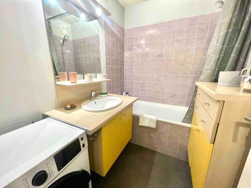 ein Badezimmer mit einem Waschbecken und einer Badewanne in der Unterkunft Le bellevue (parking gratuit) in Besançon