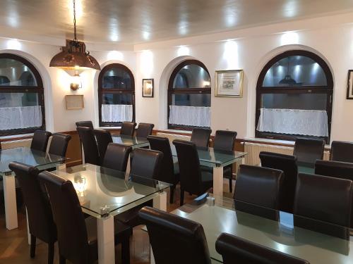 a conference room with tables and chairs and windows at Gasthof Oberschmiede in Auf der Wiese