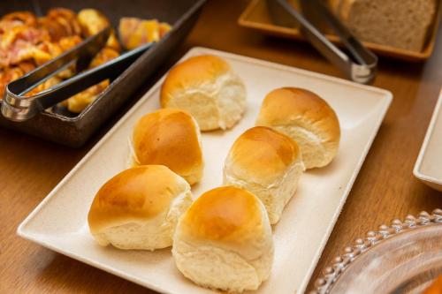 four buns on a white plate on a table at Hotel Colonial in São Lourenço