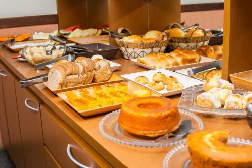 a buffet filled with different types of bread and pastries at Hotel Colonial in São Lourenço