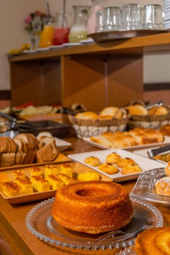a table topped with lots of different types of pastries at Hotel Colonial in São Lourenço