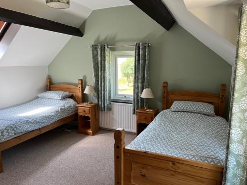 a bedroom with two beds and a window at Tremaes Solva in Solva