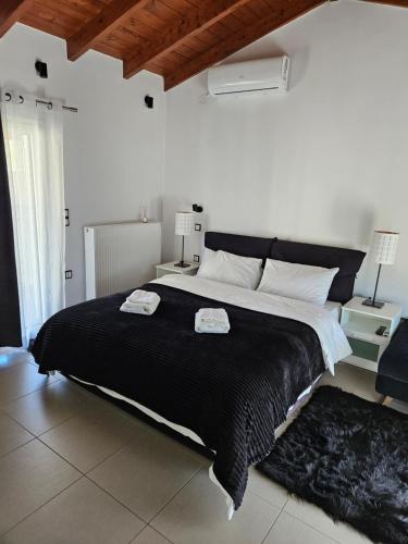 a bedroom with a large bed with a black blanket at Mary's luxury apartment Nemea in Neméa
