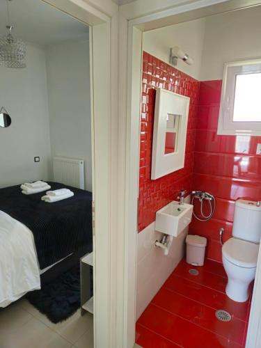 a red bathroom with a bed and a sink at Mary's luxury apartment Nemea in Neméa