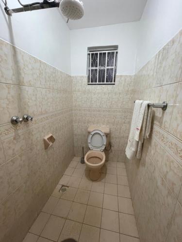 a bathroom with a toilet and a shower with a window at Wagaview place villa in Nairobi