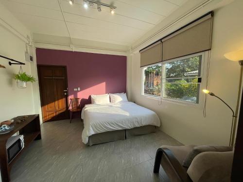 a bedroom with a large bed and a window at Self check-in apartment by Baiput Hometel in Phra Nakhon Si Ayutthaya