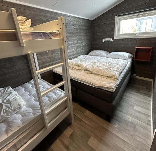 1 dormitorio con 2 literas y ventana en Sveastranda Camping, en Gullor