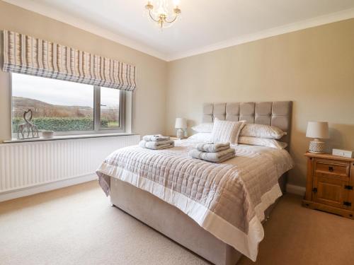 a bedroom with a large bed and a window at The Crib in Llandudno