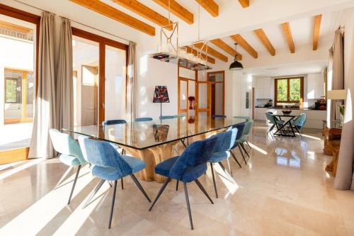 uma sala de jantar com uma mesa de vidro e cadeiras azuis em Luxury Villa Marbella em Marbella