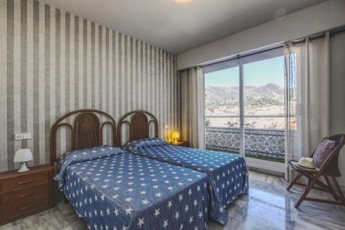 een slaapkamer met een bed en een groot raam bij 1149 Unique beachfront Penthouse Marbella Center 400m2 in Marbella