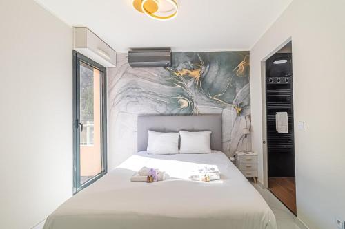 博索萊伊的住宿－Beautiful Apartment With Terrace Around Monaco，卧室配有一张白色床,墙上挂有绘画作品