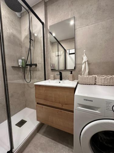 une salle de bain avec une machine à laver et un lavabo dans l'établissement Appartement Marina Deauville Marinaland, à Deauville
