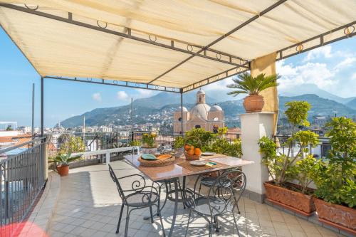 eine Terrasse mit einem Tisch und Stühlen auf dem Balkon in der Unterkunft La Casa nel Cortile in Vico Equense