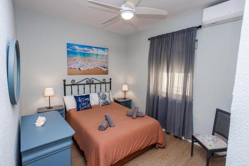 um quarto com uma cama e uma ventoinha de tecto em Apartamento Playa Santa María del Mar em Cádiz